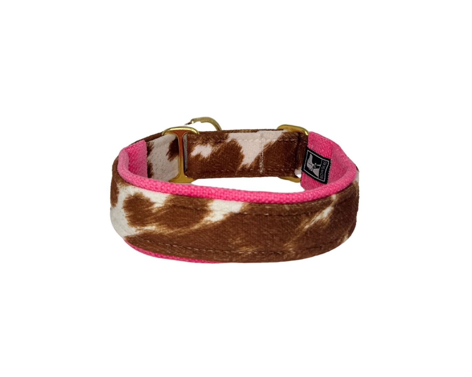 Dog collar with brown and white cow print pattern and pink interior on a white background