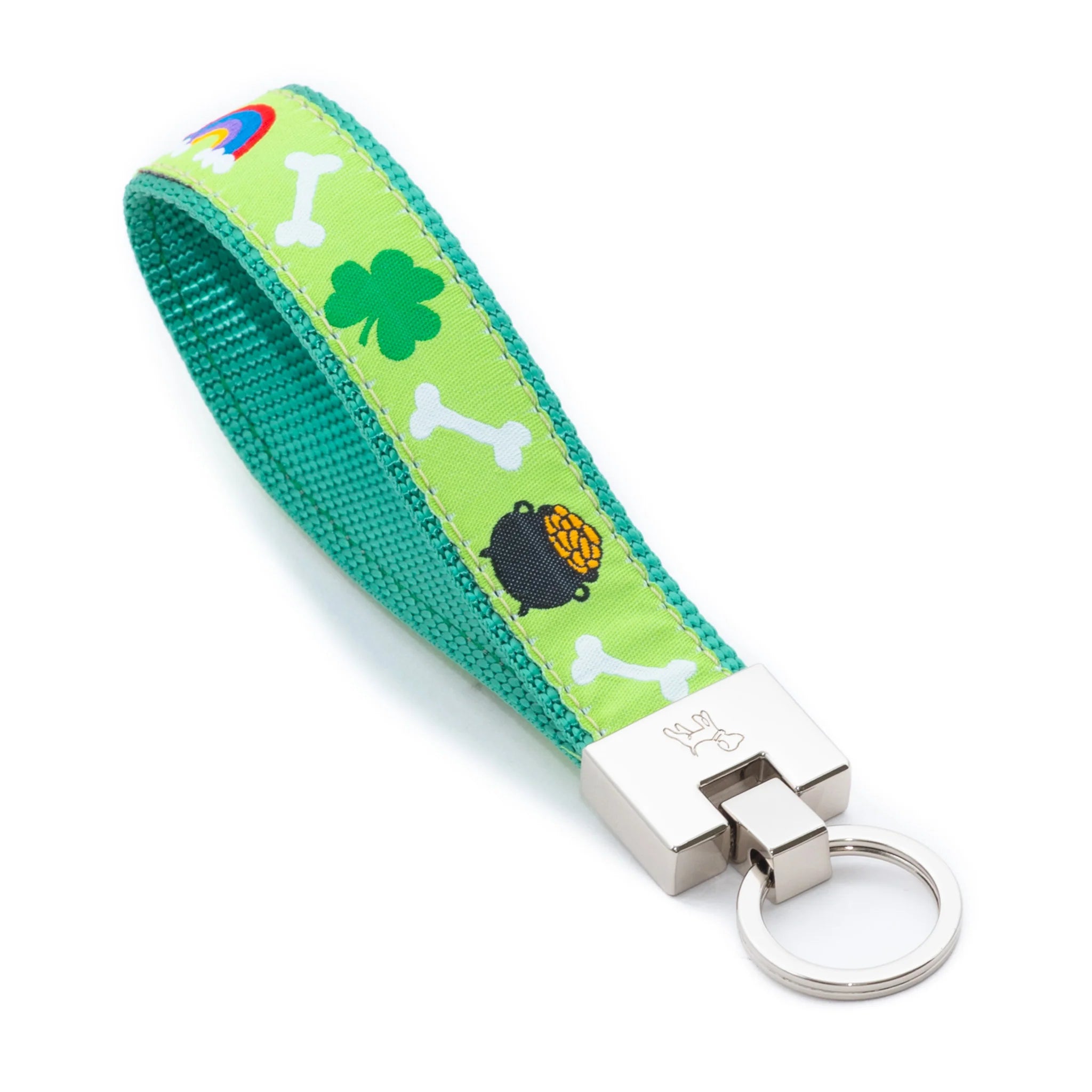 Keychain with green strap featuring shamrock, bones, and pot of gold designs on a white background.