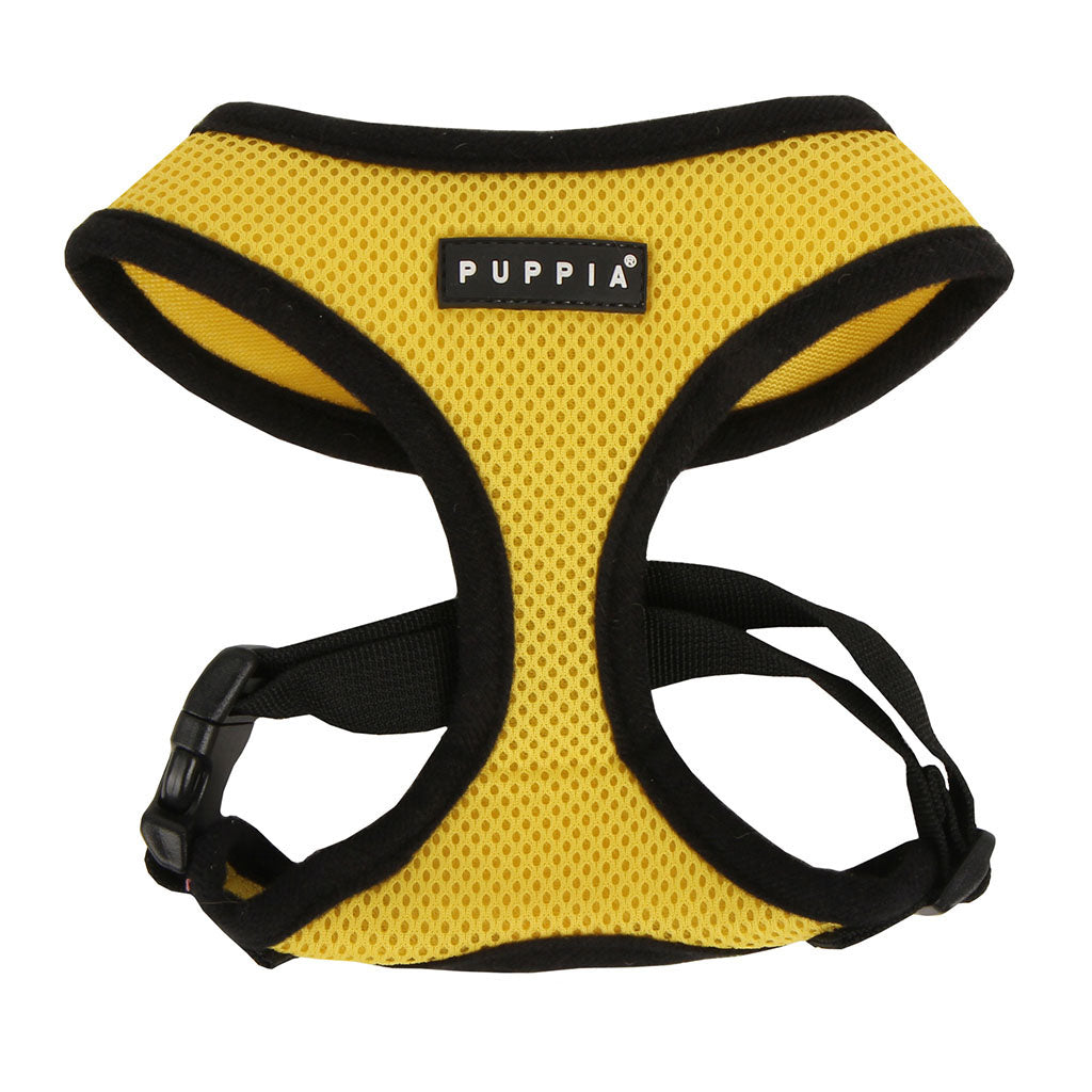 Yellow dog harness with black straps on a white background, featuring the Puppia brand.