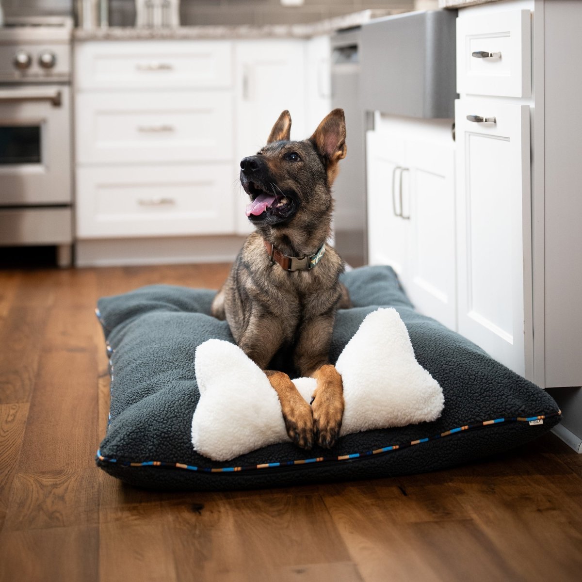 Brand Stripe Sherpa Pillow | Charcoal, with dog in a kitchen