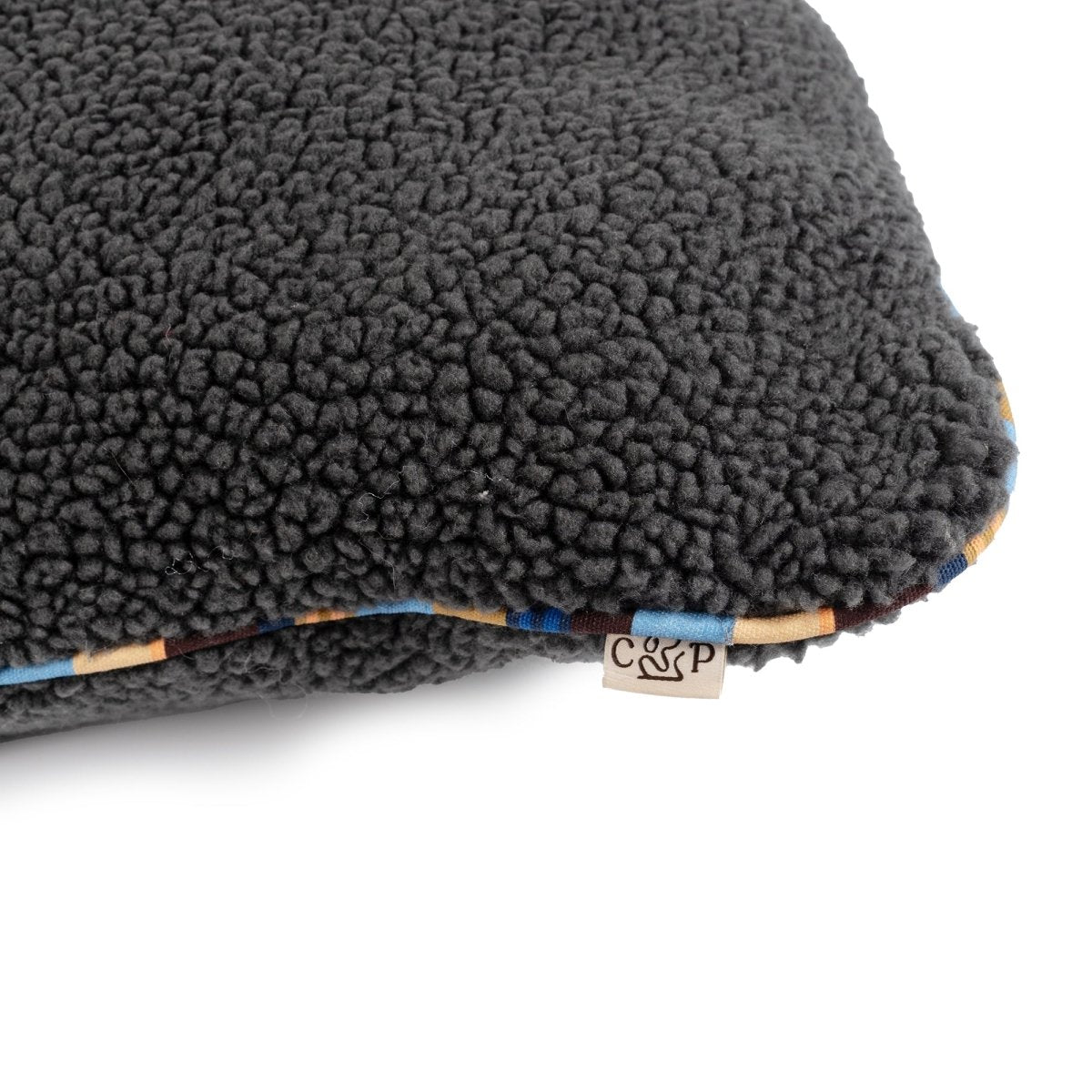 Brand Stripe Sherpa Pillow | Charcoal, close-up of sherpa and stripe cording